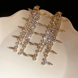 Close-up view of elegant silver needle earrings with luxury crystal water drop tassels.