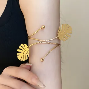 Close-up detail of a gold monstera leaf arm cuff elegantly wrapped around an upper arm