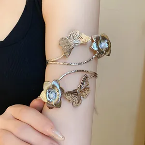 Close-up detail of a silver metallic butterfly and flower armlet worn on the upper arm
