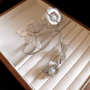 Detailed view of a silver butterfly and flower spiral arm cuff in a jewelry box