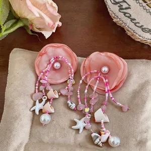 Boucles d'oreilles fleur en tissu rose avec breloques coquillage et pompons perlés