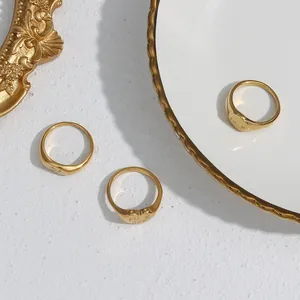 Macro view of gold-plated stainless steel rings with engraved FU K OFF lettering detail