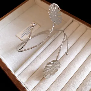 Detailed macro view of elegant silver monstera leaf arm cuff presented in jewelry box