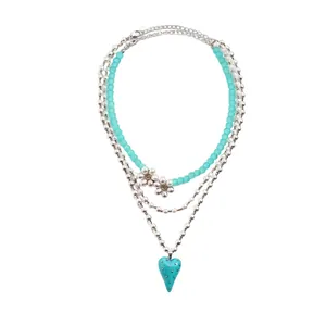 Elegante collana a più strati con perle turchesi, fiori e ciondolo a cuore.