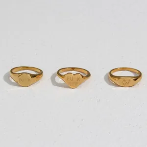 Collection of three gold plated stainless steel signet rings with engraved funny phrases