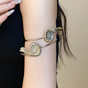 Detailed macro view of a silver-tone spiral ammonite armlet worn on upper arm accessory