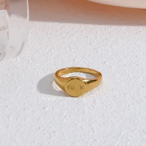 Macro view of gold-plated stainless steel signet ring featuring engraved text detail