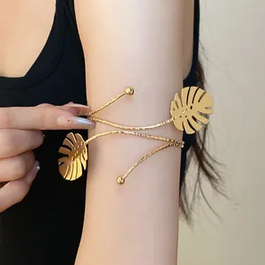 Elegant gold monstera leaf arm cuff bracelet with a minimalist wrap-around design