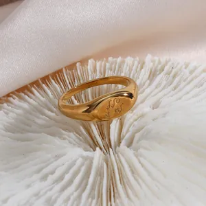 Macro shot of 18K gold plated stainless steel signet ring with engraving.