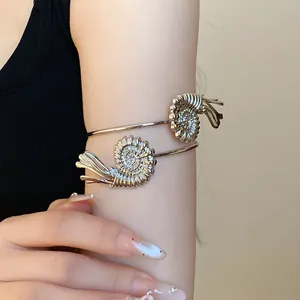 Detailed close-up view of a silver metallic shell-designed fashion armlet on the upper arm.