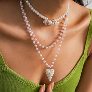 Vista dettagliata della collana di perle a più strati con eleganti ciondoli a cuore e fiori
