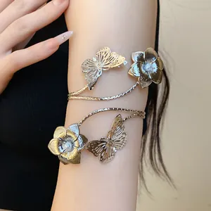 Detailed macro view of elegant silver armlet featuring butterfly and flower motifs with pearls.
