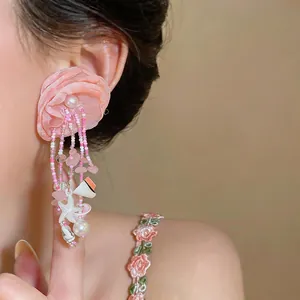 Vue détaillée de boucles d'oreilles fleur en tissu rose avec perles pour les vacances