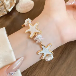 Elegantes goldfarbenes Seestern- und weißes Perlenarmband für einen Urlaubslook