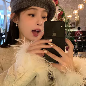 Elegant zircon snowflake pearl drop earrings worn by model in a stylish cafe setting