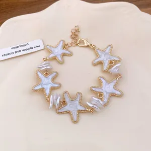 Nahaufnahme eines eleganten Goldarmbandes mit Seesternen und weißen Perlen auf Teller.