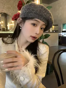 Close-up of star-shaped snowflake pearl earrings worn by a model in a cozy cafe setting