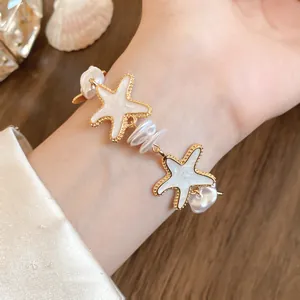 Makro-Detailaufnahme eines eleganten Seestern-Armbandes mit Perlen am Handgelenk für den Urlaub