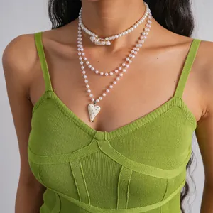 Dettaglio di collana di perle a più strati con pendente a cuore in strass su modella