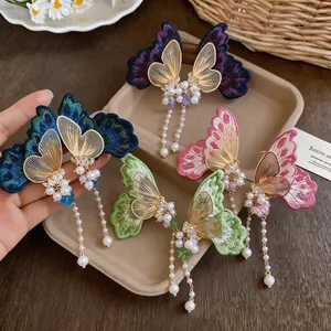 Detailed view of colorful embroidered butterfly earrings with elegant pearl tassels.