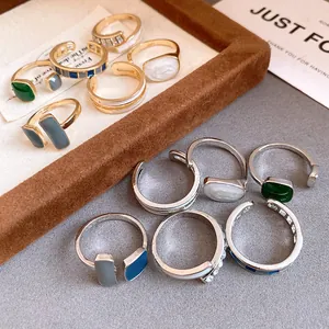 Dettaglio di vari anelli aperti geometrici in smalto con finitura oro e argento