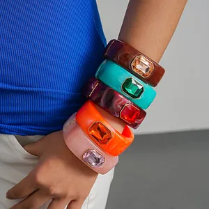 Primo piano di bracciali in resina stile dopamina con cristalli sfaccettati indossati al polso