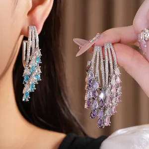 Close-up of 18k gold plated teardrop tassel earrings with sparkling colorful zircons