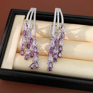 Detailed close-up of 18k gold plated earrings featuring purple teardrop zircon tassels