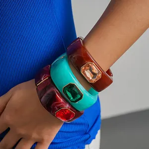 Primo piano di bracciali in resina con grandi cristalli sfaccettati indossati sul polso