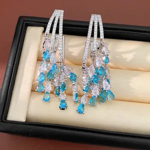 Close-up detail of luxury teardrop tassel earrings featuring blue and white zircons