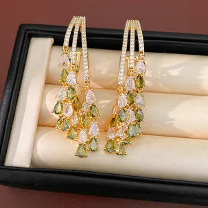 Detail of 18k gold plated drop earrings with green and white pear-shaped zircons