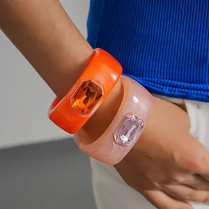 Dettaglio di vivaci bracciali in resina stile dopamina con grandi gemme sfaccettate