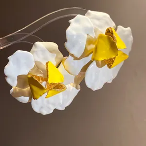 Close-up detail of vintage white and yellow enamel flower stud earrings for women