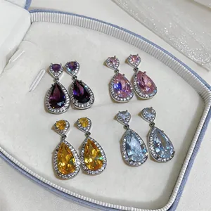 Detailed view of four pairs of teardrop zircon earrings in purple, pink, yellow, and blue.