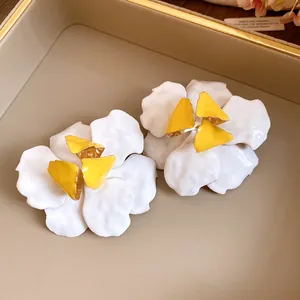 Detailed view of vintage flower earrings with white petals and yellow centers