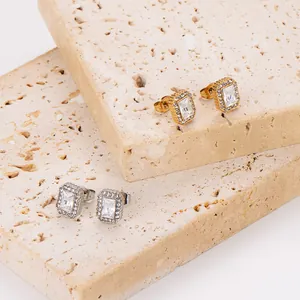 Dettaglio macro di eleganti orecchini a lobo in zircone quadrato, finiture oro e argento