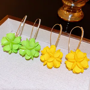 Détail en gros plan de boucles d'oreilles fleurs en vert tilleul et jaune vif chic