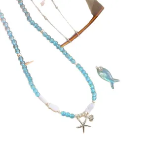 Handmade ocean-themed aquamarine beaded necklace with silver fish and starfish charms
