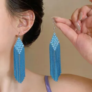 Elegant light blue beaded earrings with long chain fringe tassels shown on model wear