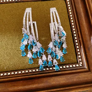 Close-up of water drop tassel earrings with blue zircons in 18k gold plating finish