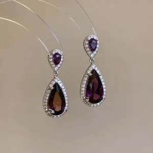 Elegant teardrop zircon earrings featuring a deep purple stone and clear halo setting detail.