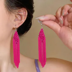 Close-up detail of fuchsia beaded earrings featuring long chain tassels and diamond shape