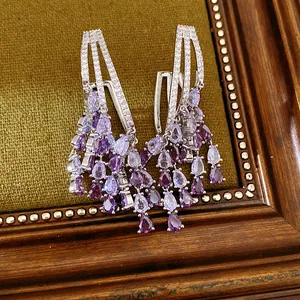 Macro view of purple pear-shaped cubic zirconia tassels on high-end royal style earrings.