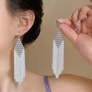 Detailed view of silver rhombus beaded earrings with elegant long chain tassels.