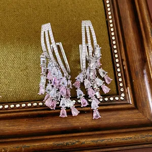 Detailed view of 18k gold plated earrings with pink and clear teardrop zirconia stones