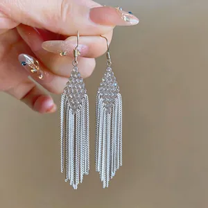 Close-up of diamond-shaped beaded earrings with long silver-tone chain tassels