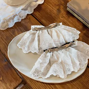 Detailed view showing the back of elegant white lace bow hair clips with spring clips