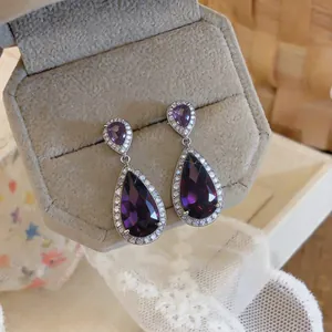 Macro detail of elegant purple teardrop zircon earrings with exquisite micro-pave setting