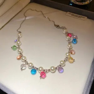 Close-up of asymmetric pearl necklace with colorful faceted crystal beads in a box