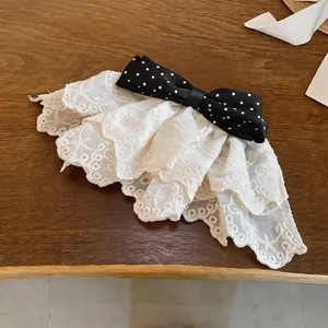 Close-up view of a Korean style lace bow hair clip featuring a black polka dot pattern.